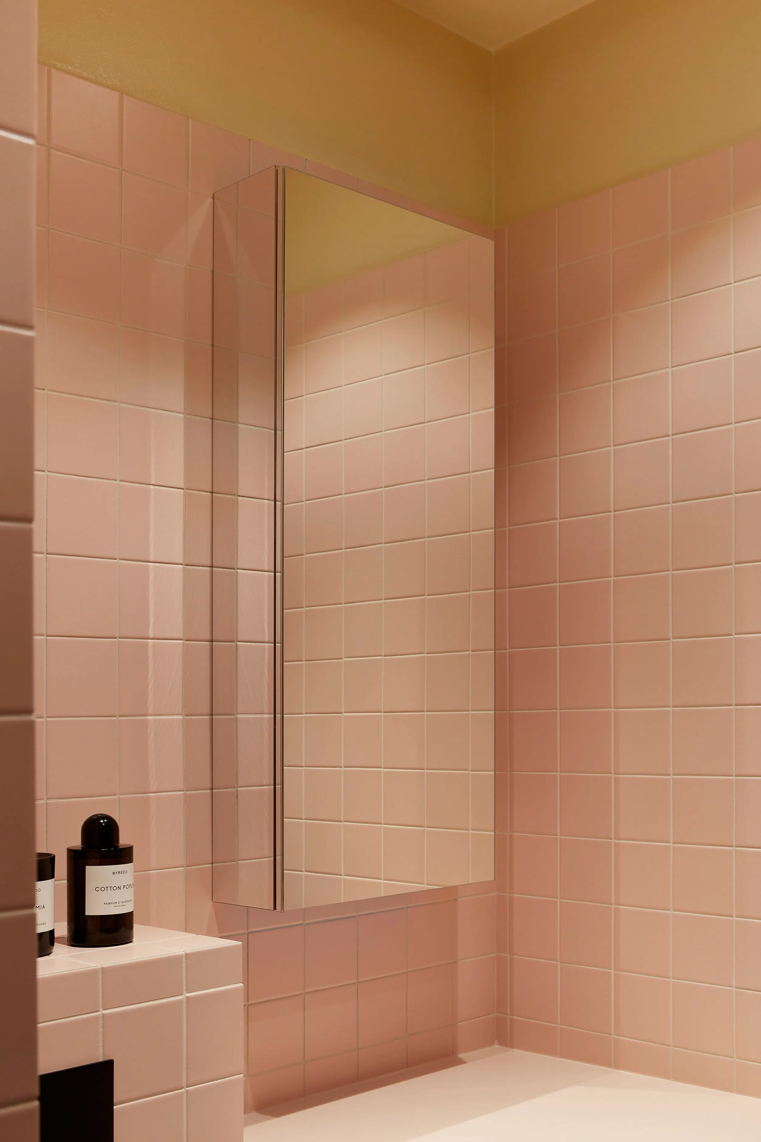 Badrum med rosa klinker och spegelskåp