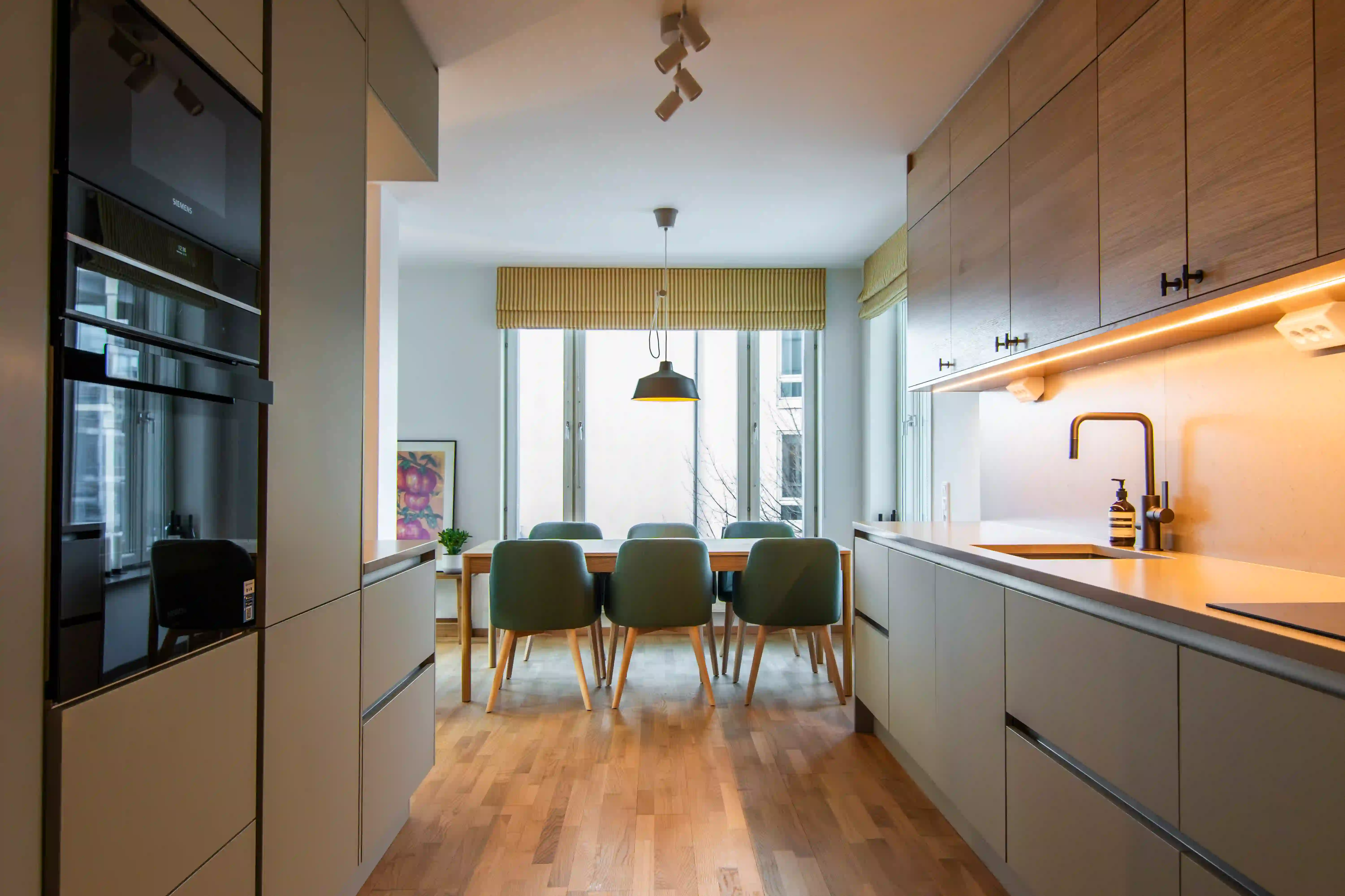 Nyrenoverat kök med skåpluckor i trä och varm grå