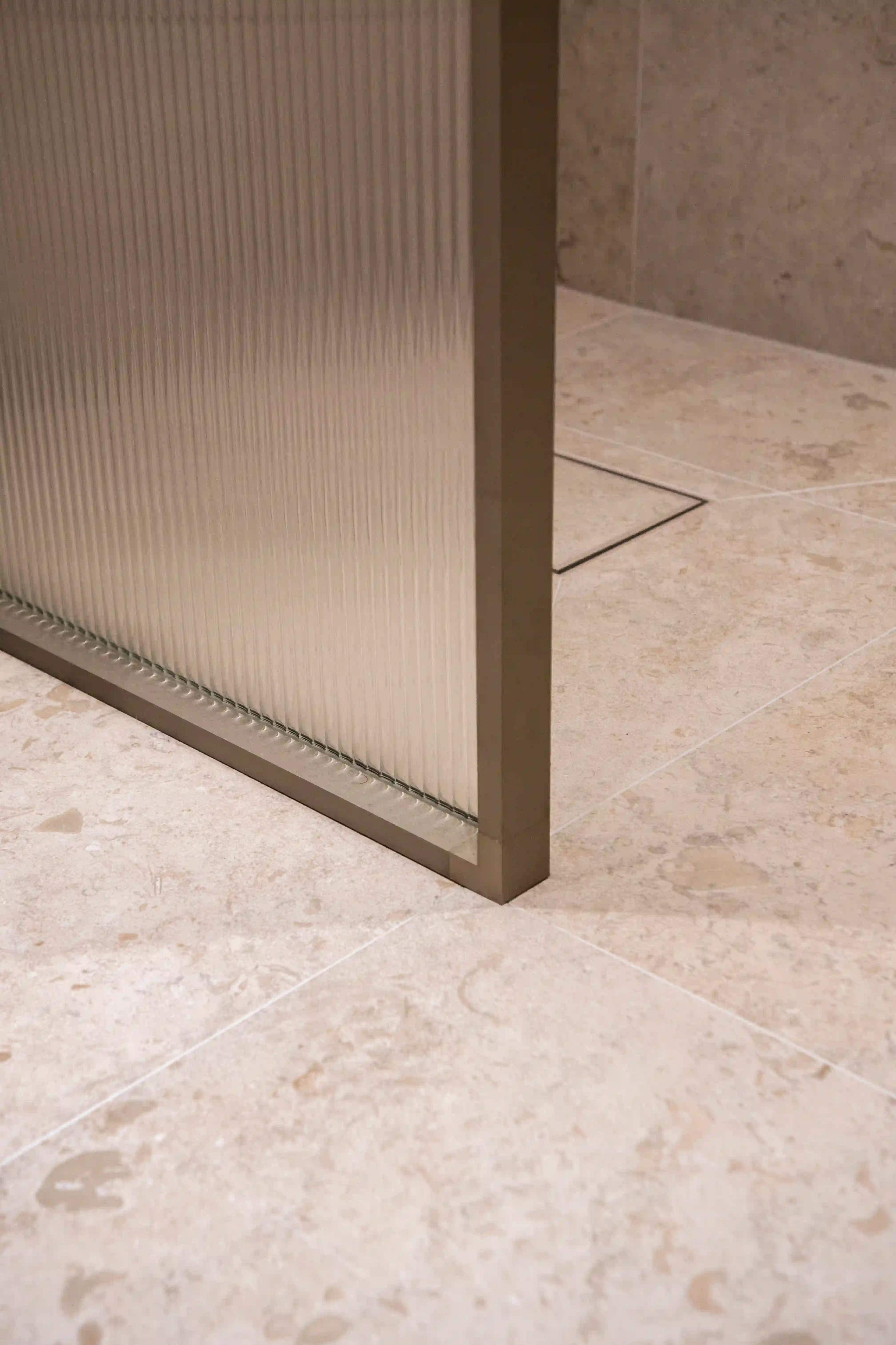 Duschvägg med struktur och kuvertskuren golvbrunn