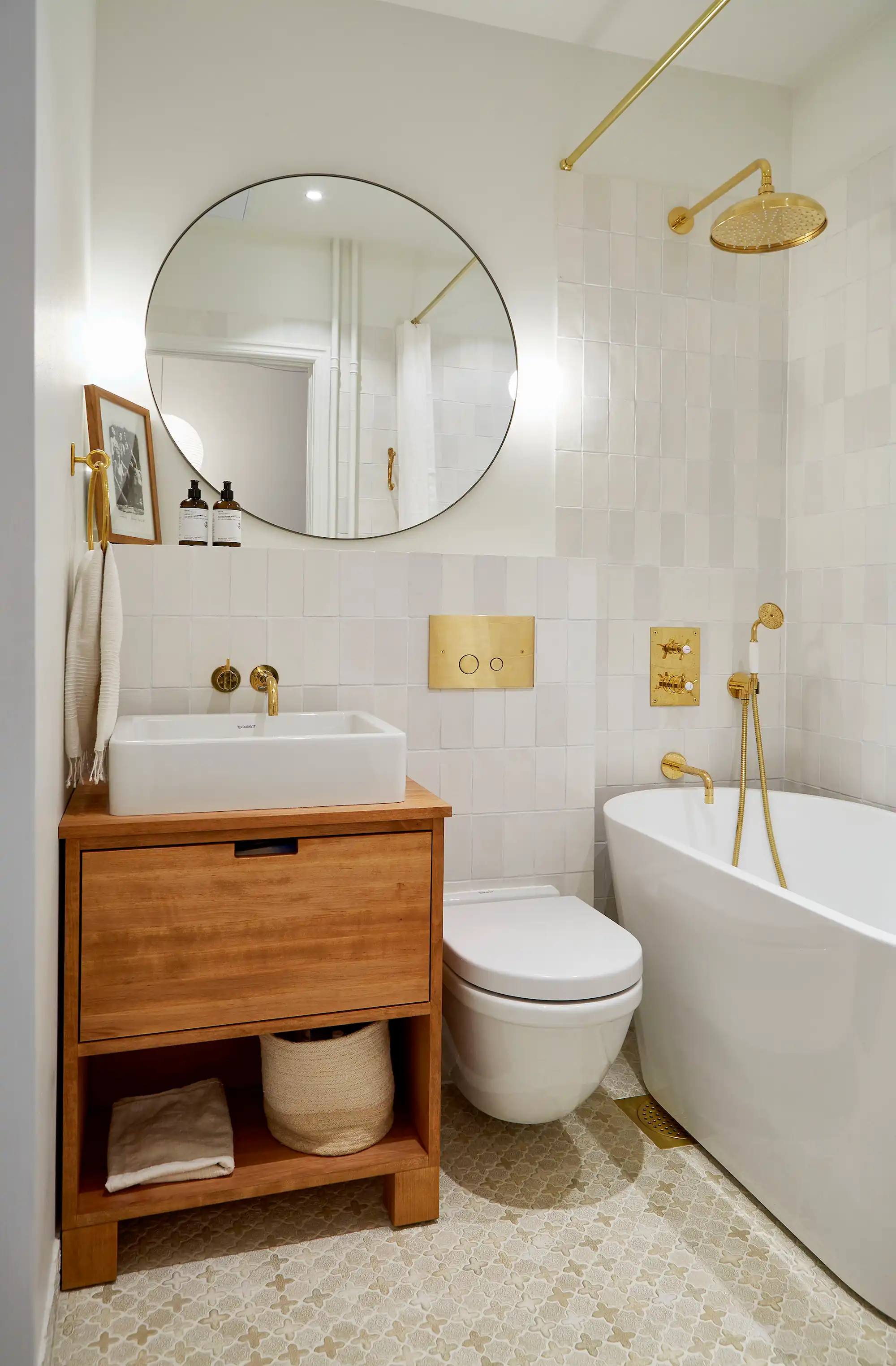 Badrumsrenovering med ljust klinker/kakel och gulddetaljer