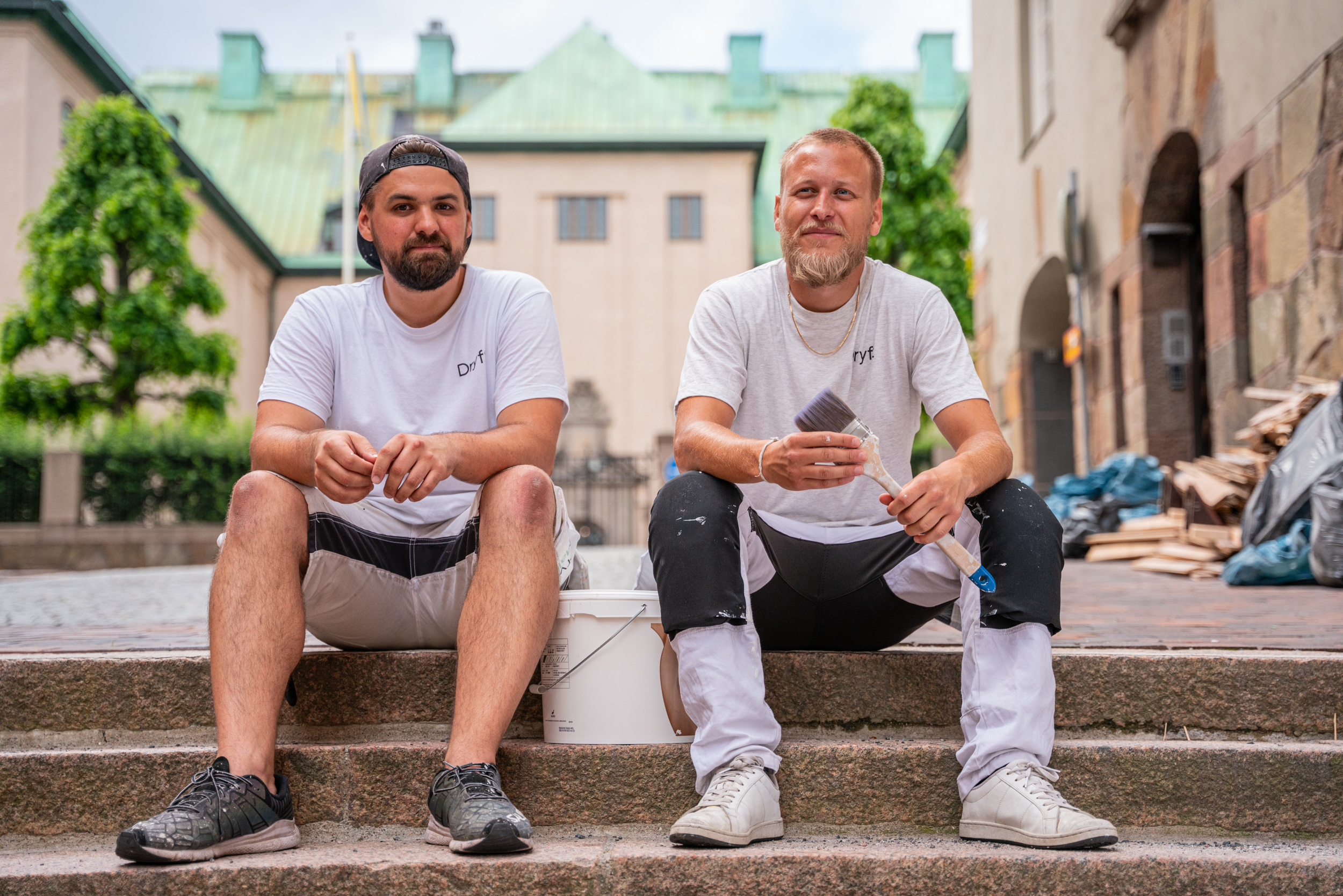 Två målare med pensel på trappa