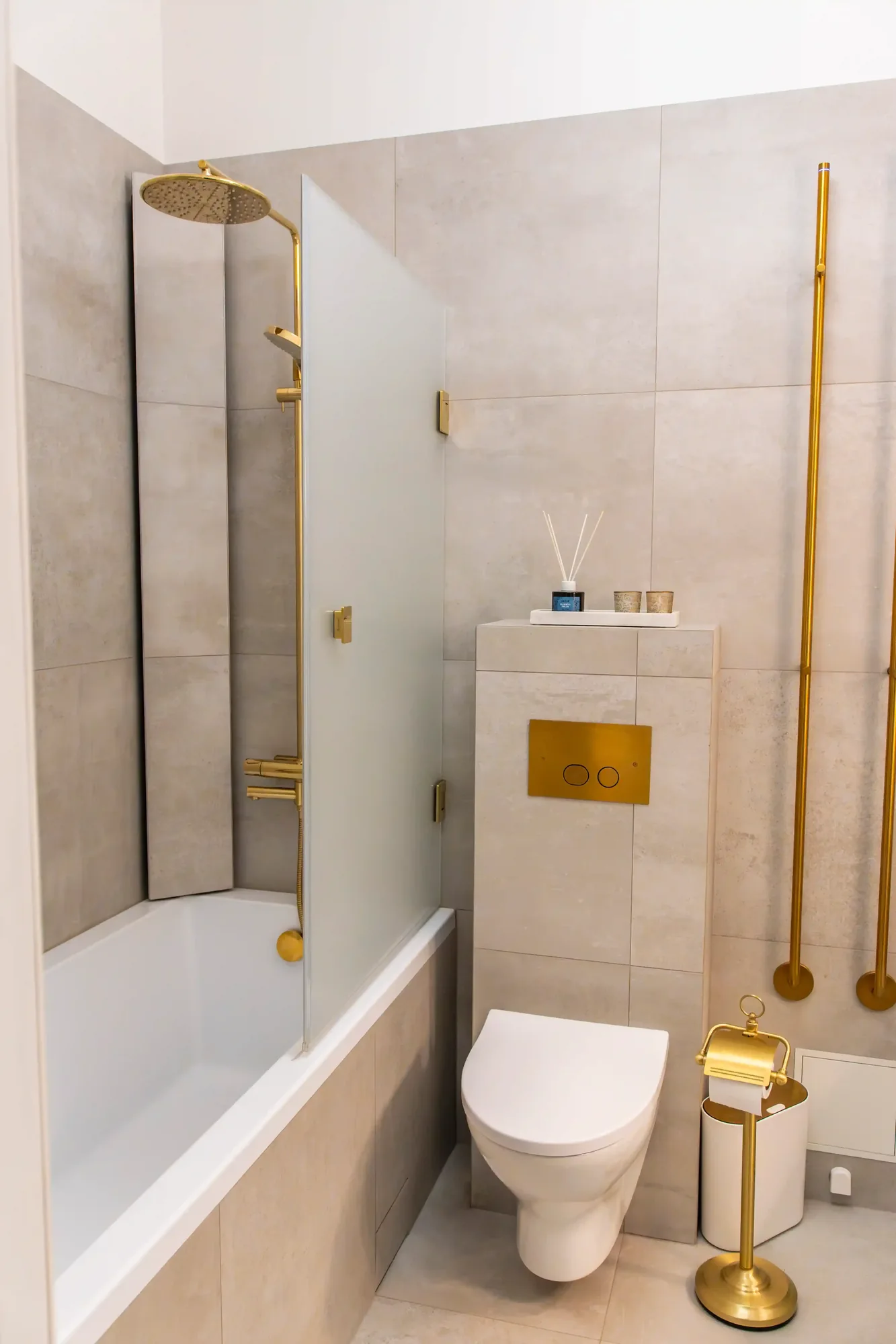 Badrumsrenovering i Stockholm med sekelskiftesstil, badkar, beige kakel och mässingsdetaljer