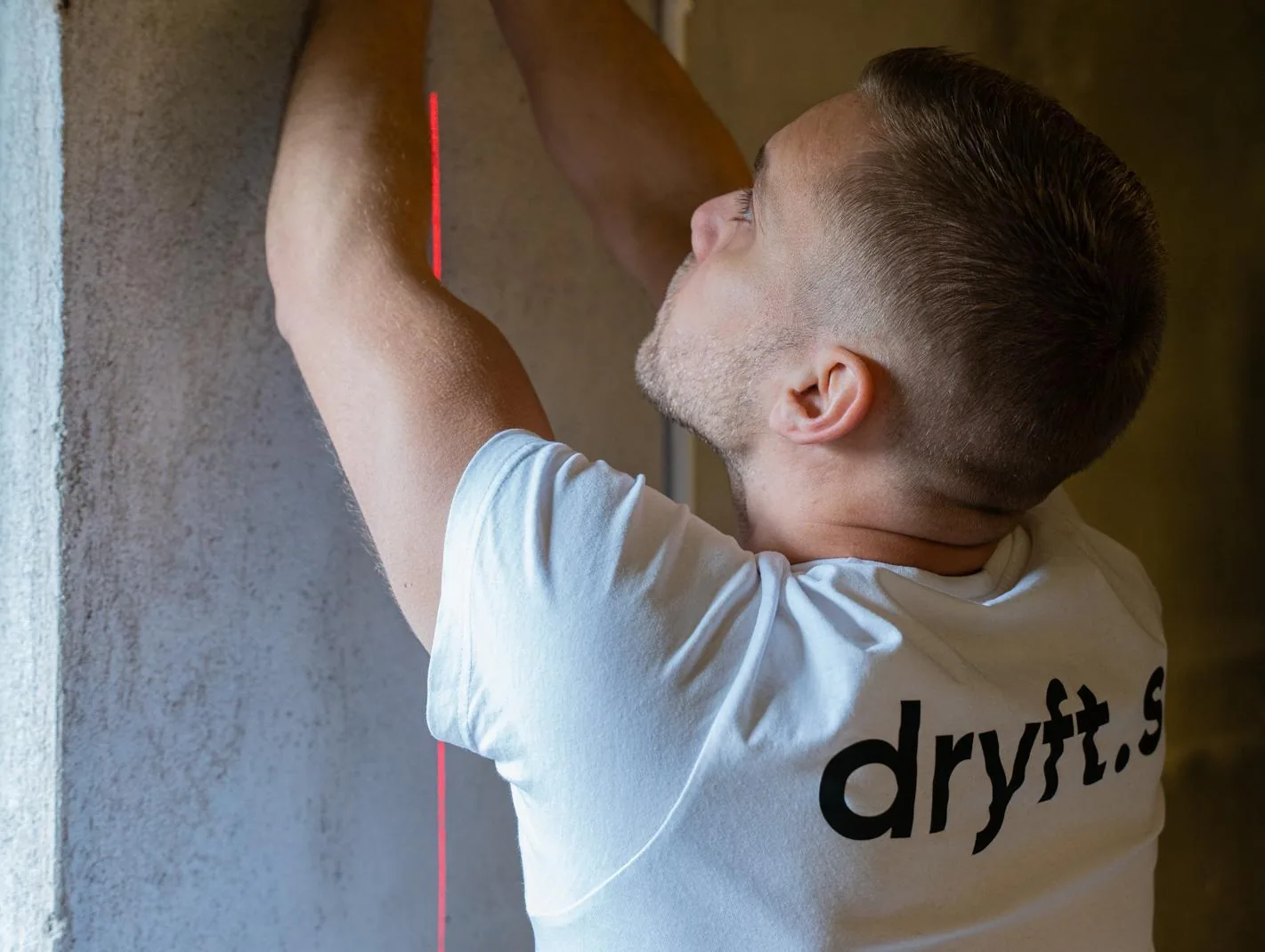 Elektriker från Dryft mäter upp med laser på en vägg